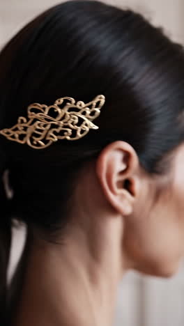 close-up of a golden hair clip on dark ponytail