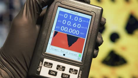 scientist holds a geiger counter to measure the microsieverts per hour of radiation at nuclear facility. nuclear disaster and radiation fallout concepts.