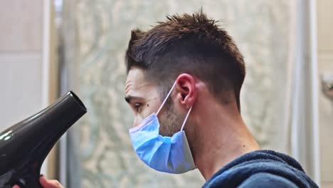 hombre con una máscara protectora secándose el pelo
