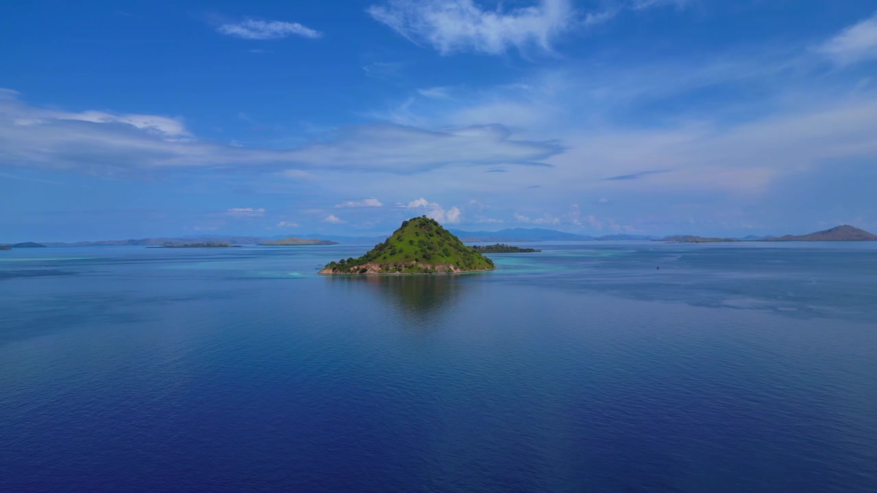Komodo Insel mit Sandstrand, klarem Meer und einem kleinen Steg unter blauem Himmel. Unglaubliche Luftaufnahme, Drohnenpanorama von oben.