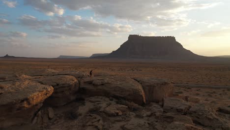 vista aérea, hombre corriendo sobre rocas en la colina al atardecer en el desierto de utah, ee.uu.