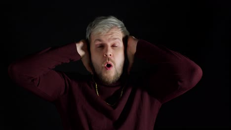 sorprendido hombre elegante sintiendo emoción, mirando a la cámara y sosteniendo las manos cerca de la cara