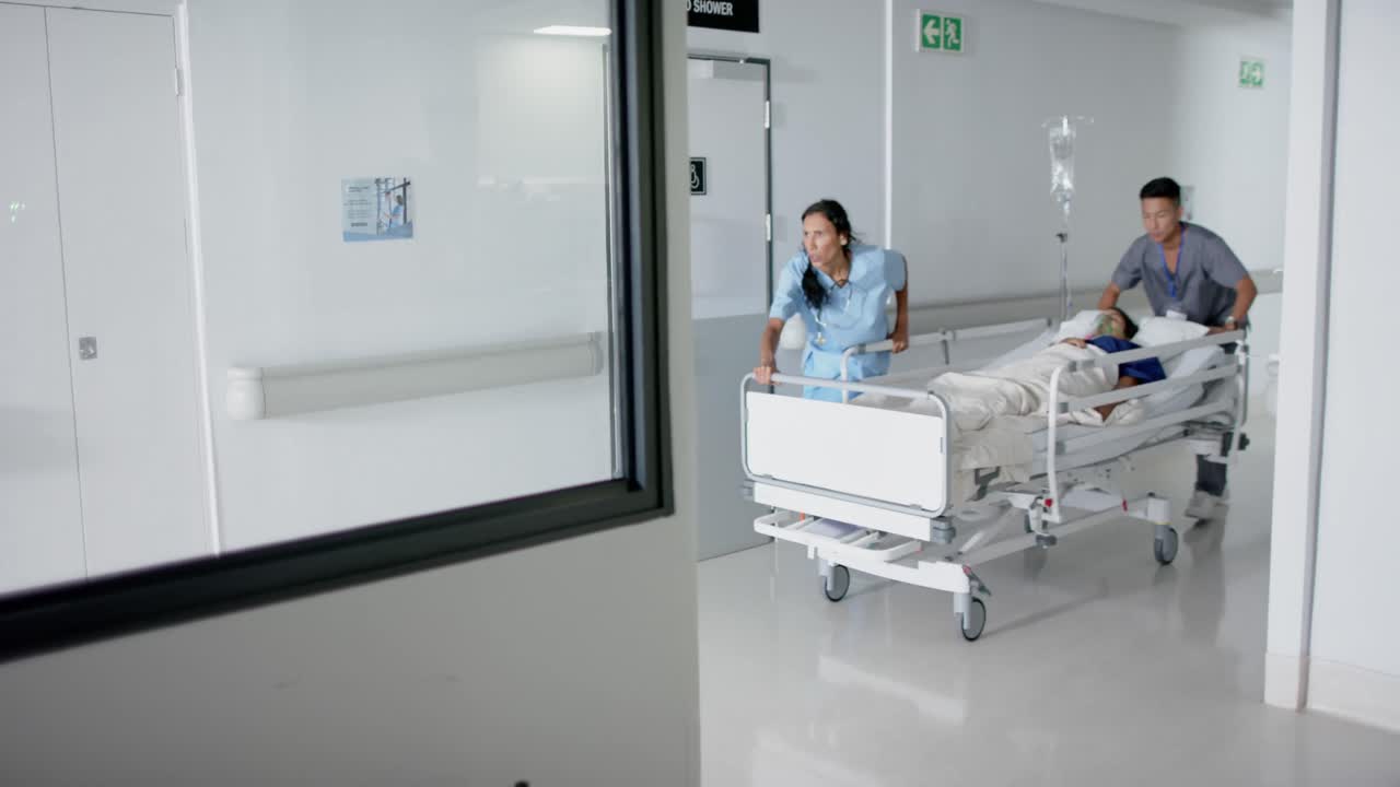 Meşgul çeşitli doktor ve cerrahların, hastane yatağındaki bir hasta ile ağır çekimde yürümesi.
