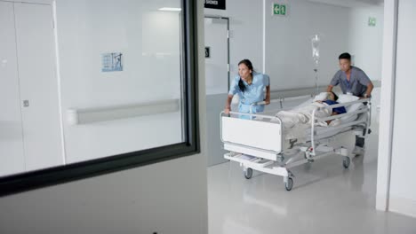 busy diverse doctor and surgeons walking with patient on hospital bed in slow motion