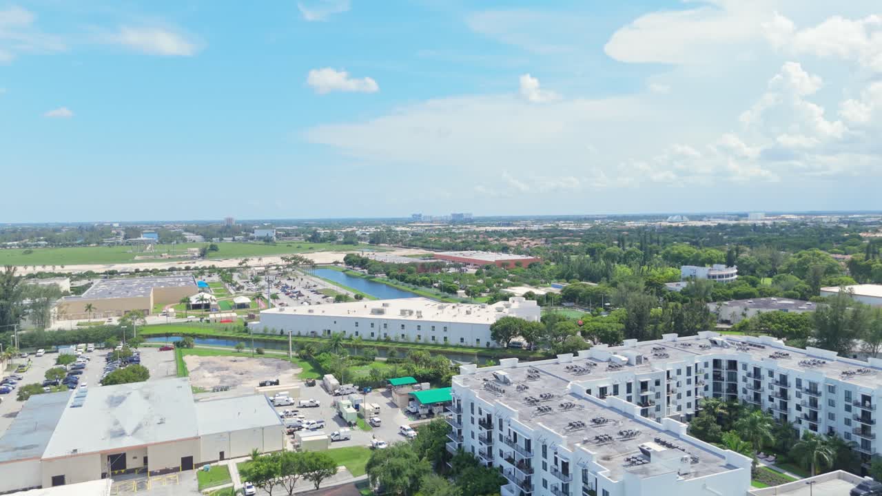 Apartment Blocks with parking cars on park deck in Doral, Florida. Aerial forward wide shot. Sunny day with palm trees in suburb district