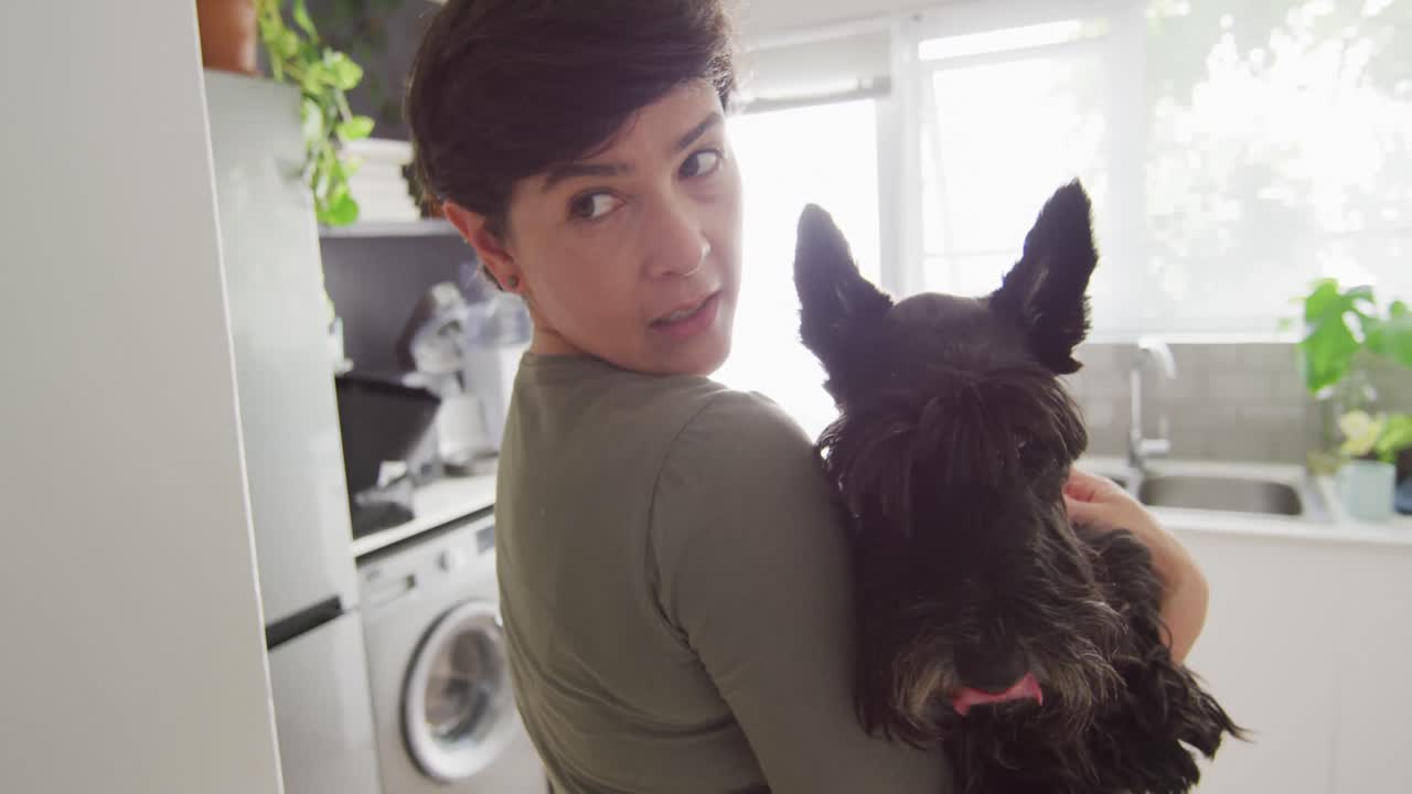 집 에서 주방 에서 개 를 들고 있는 백인 여자