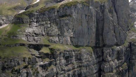 flying next to the vertical flanks of the oeschinen valley in the swiss alps