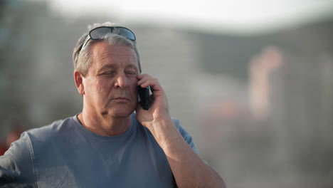 retired man talking on the phone outdoors