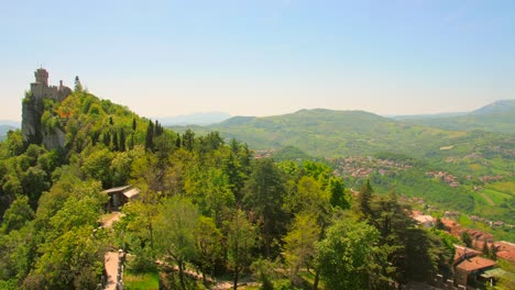 three towers of san marino on monte titano mountain with green forest in san marino, italy