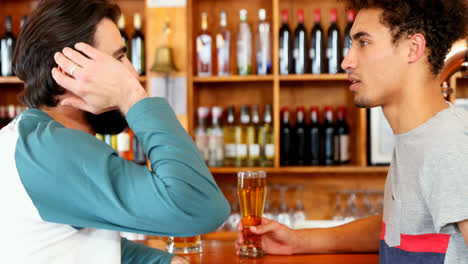 friends interacting with each other while having beer at counter 4k