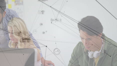 Office workers collaborating at desk in bright workspace, overlaying business data charts and nodes