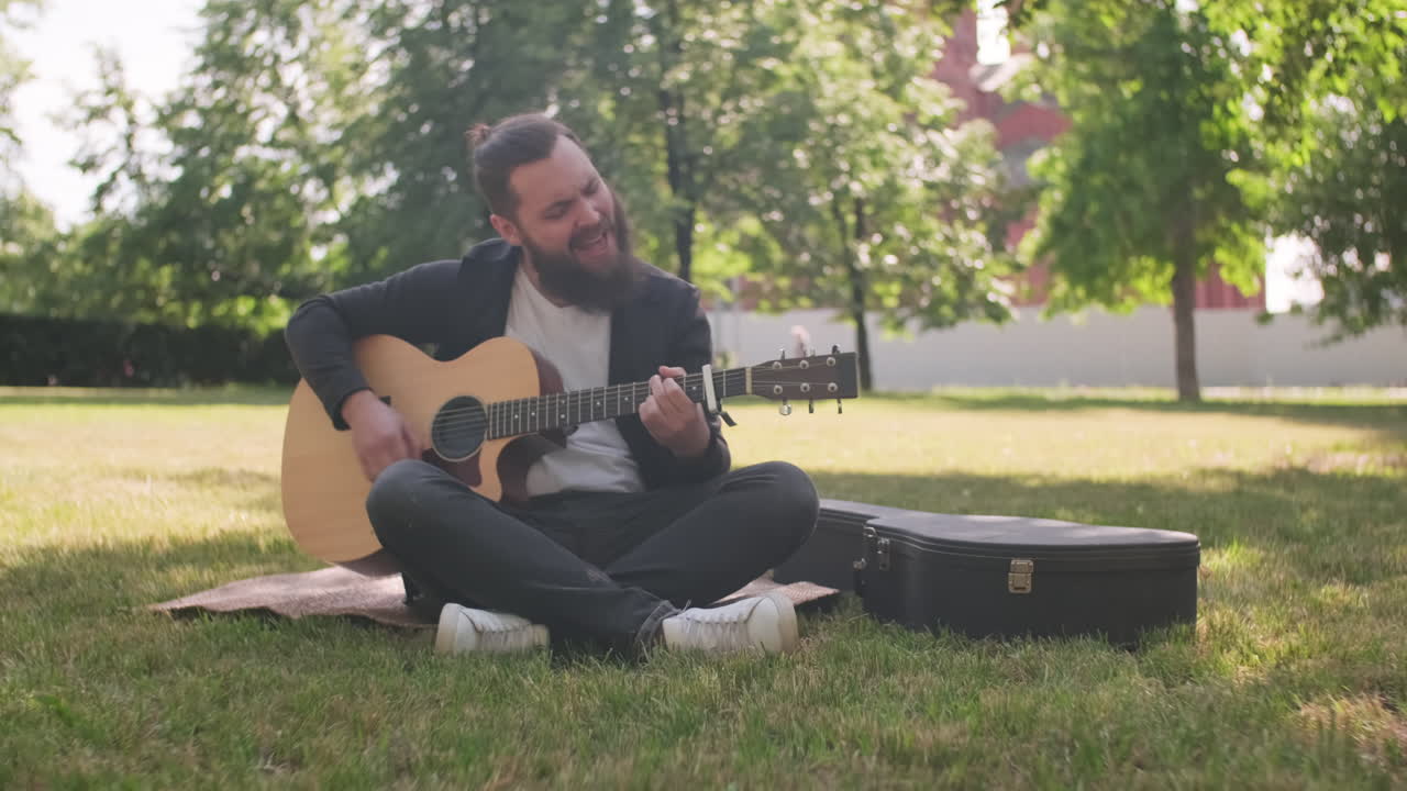 Male Musician Playing Guitar in Park