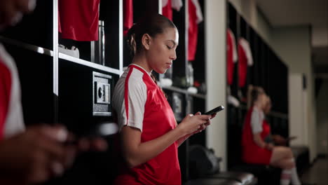 athletes in locker room using smartphones