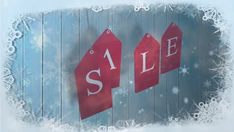 snowflakes falling over against sale text on red dangling red tags