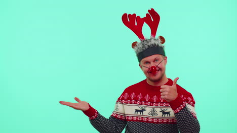 Mann-Im-Roten-Pullover,-Weihnachtsmann,-Zeigt-Daumen-Nach-Oben-Und-Zeigt-Auf-Leere-Stelle,-Werbefläche