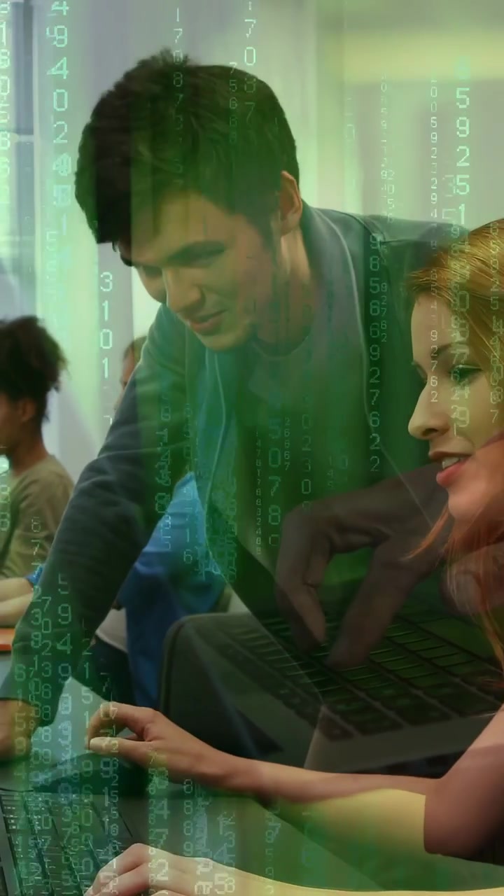 Vertical video: Male coming guiding woman typing on laptop for training, green code falling across
