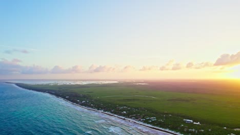 tulum, mexico. wide aerial drone footage of beautiful golden sunset setting behind yucatan caribbean beach,