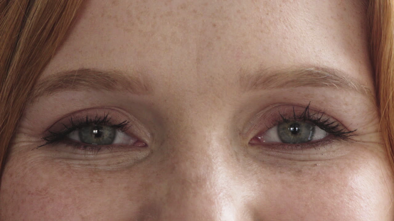 cerca los ojos de la mujer mirando feliz a la cámara cabeza roja rostro de pecas femeninas