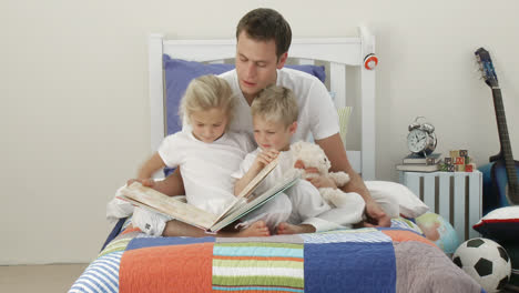 Papá-Leyendo-Con-Sus-Hijos-En-El-Dormitorio