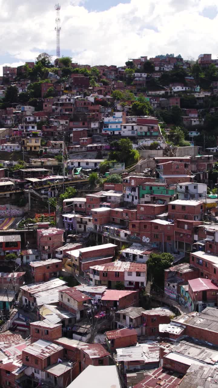 Aerial view of outdoor connecting houses in Comuna 13, Medellin, Colombia, providing essential transportation in challenging terrain. Vertical video, Pull back shot