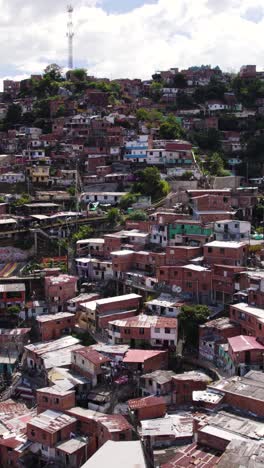 aerial view of outdoor connecting houses in comuna 13, medellin, colombia, providing essential transportation in challenging terrain. vertical video, pull back shot