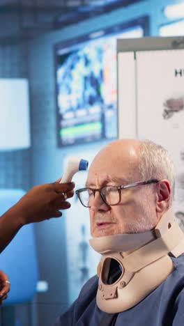 vertical video medical staff consults old man wheelchair user wearing cervical neck collar