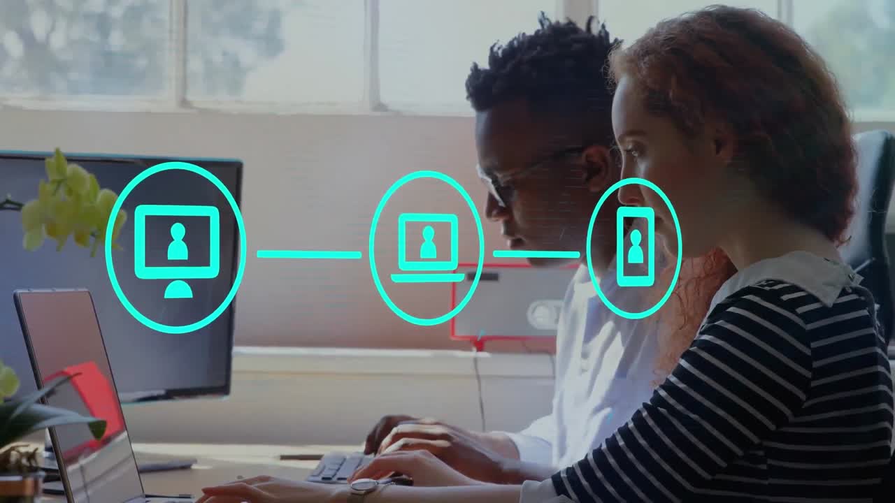 Animation of network of digital icons against diverse man and woman using laptop at office