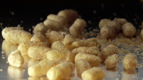 Sweet-Corn-sticks-being-drop-on-black-stainless-steel-surface---Detail-Slow-motion-close-up-shot