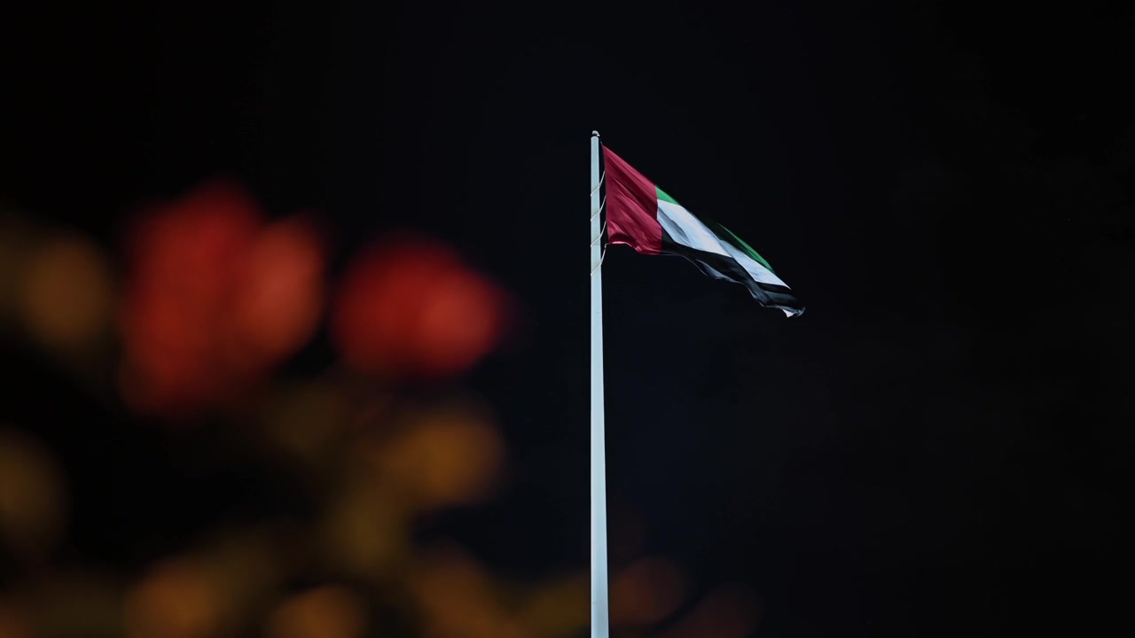 The UAE national flag proudly waving in the evening breeze.