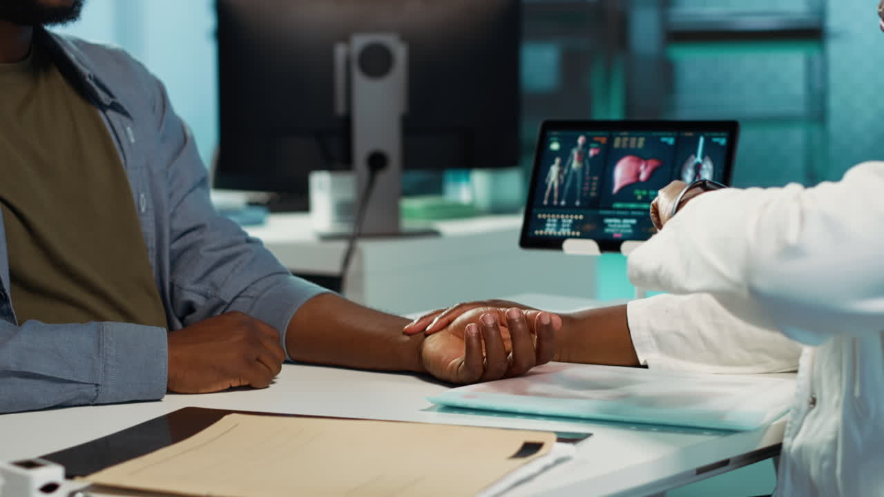 Physician measuring the heart rate of a young man by using her smartwatch