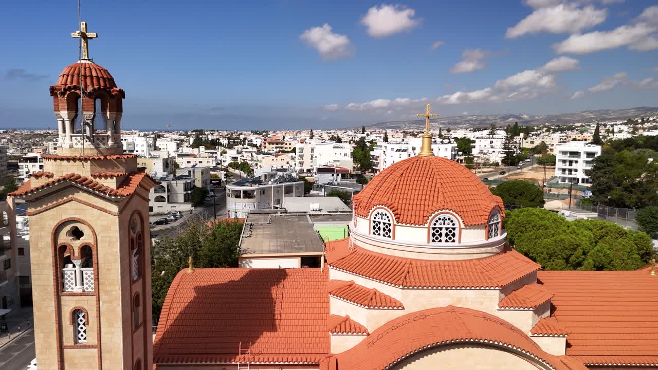 Discover the intricate architecture of a historic church in Cyprus, set against a backdrop of a vibrant cityscape and surrounded by lush greenery