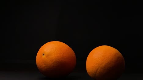 rolling orange fruit, black background