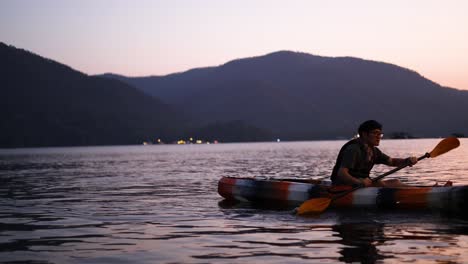 person kayaking on calm water at sunset