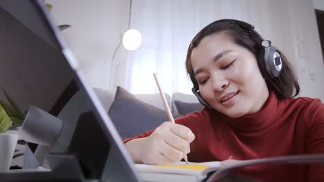 집에서 온라인 회의를 위해 헤드폰이 있는 태블릿을 사용하는 사업가 빨간 셔츠