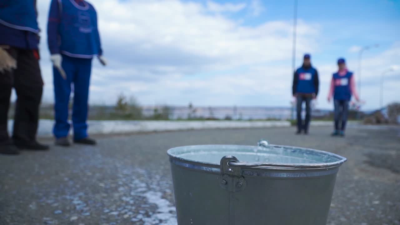 지역 사회 의 자원 봉사자 들 이 도시 거리 를 청소 하고 있다