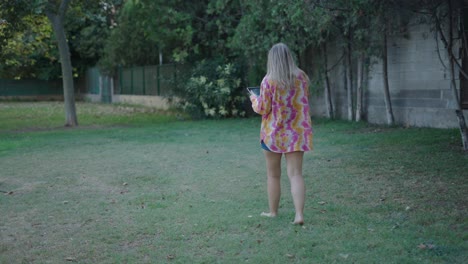 woman walking in a park with a tablet