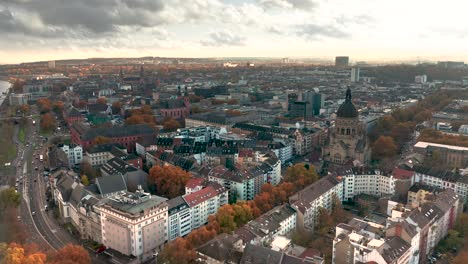 mainz with a drone in fall with golden leaves and dramatic light showing the christuskirche of the part neustadt and the dome in the back