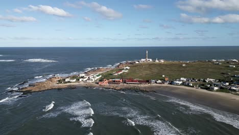 drone-rotate-above-Cabo-Polonio-Hamlet,-Uruguayan-Coast-in-Rocha,-lighthouse-travel-holiday-off-grid-destination