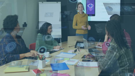 tech team collaborating around table, with animated interface graphics showing mobile app data