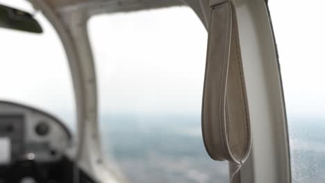 closeup of grab handle strap on board of small private airplane, handheld