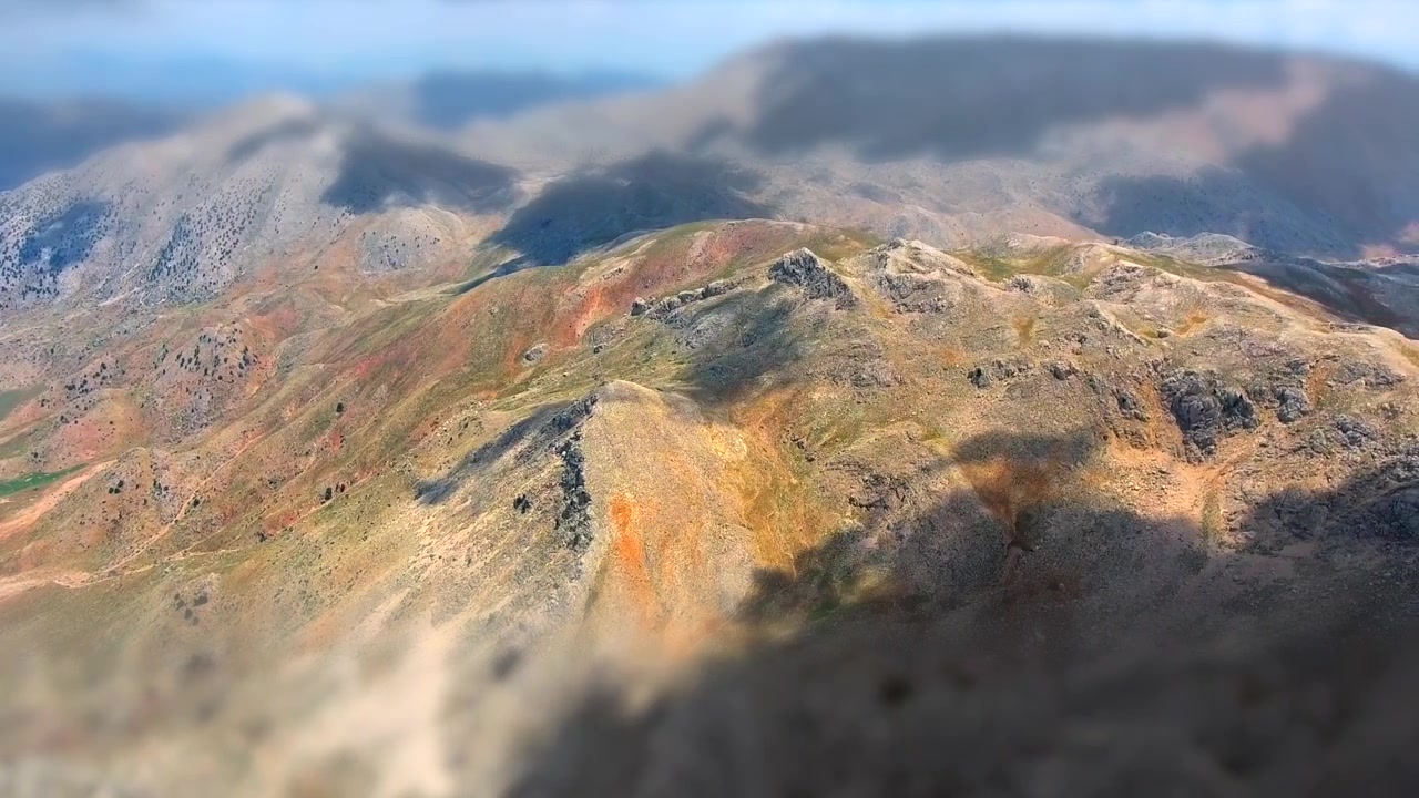 Vista Aerea di un Paesaggio Montano Accidentato con Ombre di Nuvole in Movimento