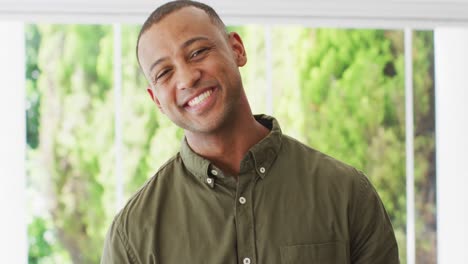 Portrait-of-happy-biracial-man-looking-at-camera-and-laughing