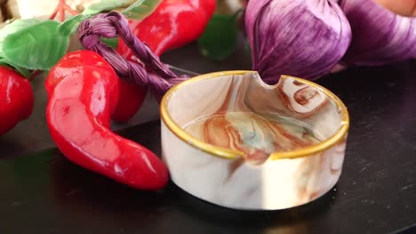pouring oil over garlic and chili peppers