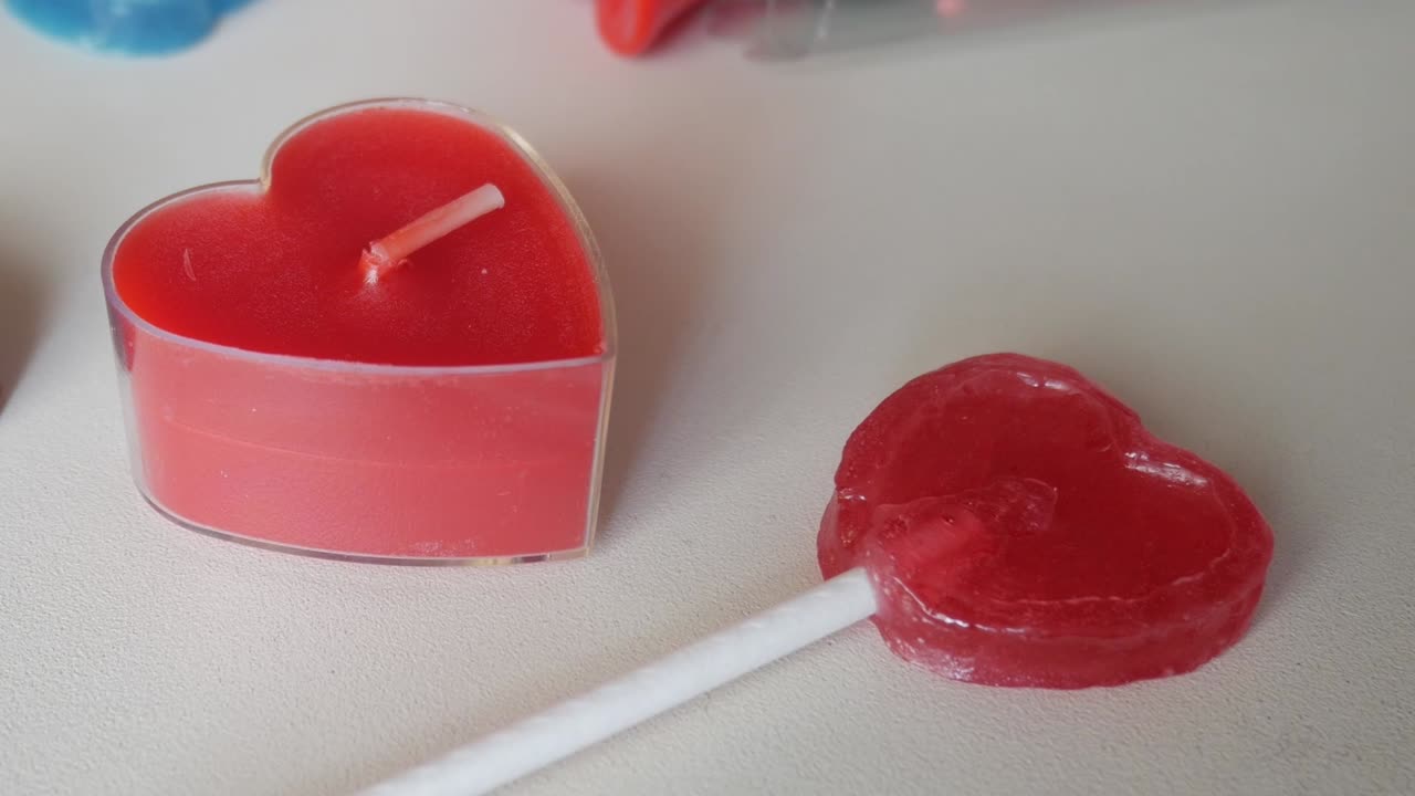 Heart-shaped lollipop and candle in red, perfect for Valentine's Day celebrations