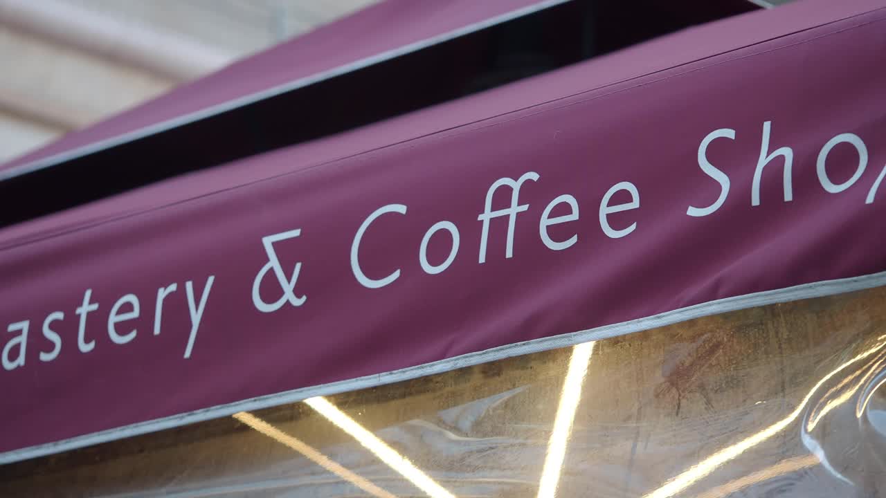 Insegna di torrefazione e caffetteria su una tenda da sole bordeaux