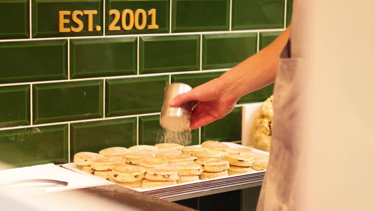 rociando azúcar en pasteles galeses recién horneados
