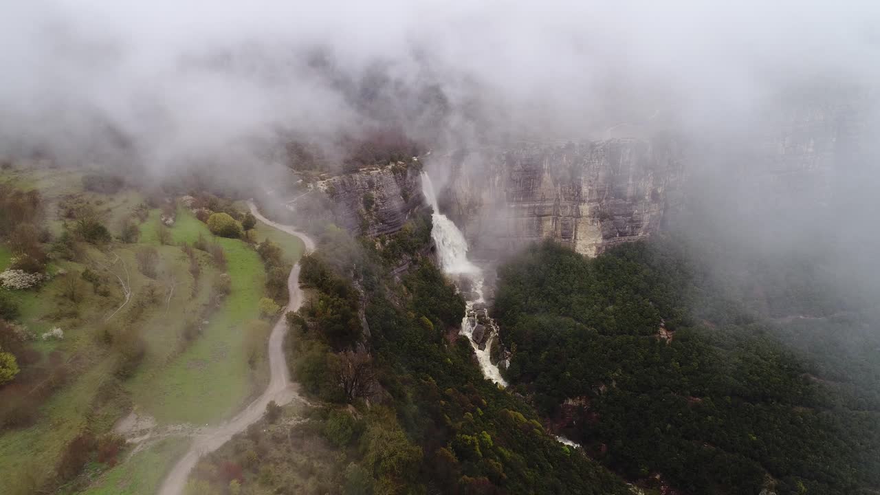 Thick mist surrounds Salt de Sallent falls in mountain region of Rupit, Spain