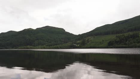 Ein-Sanft-Plätschernder-See-Mit-Bewaldeten-Hügeln-Im-Hintergrund