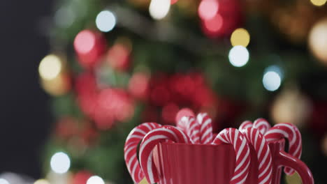 Video-of-red-mug-with-christmas-cnady-canes-and-christmas-tree-lights-with-copy-space