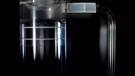 air bubbles surfacing through water in a see through tube as part of a renewable energy experiment exhibit